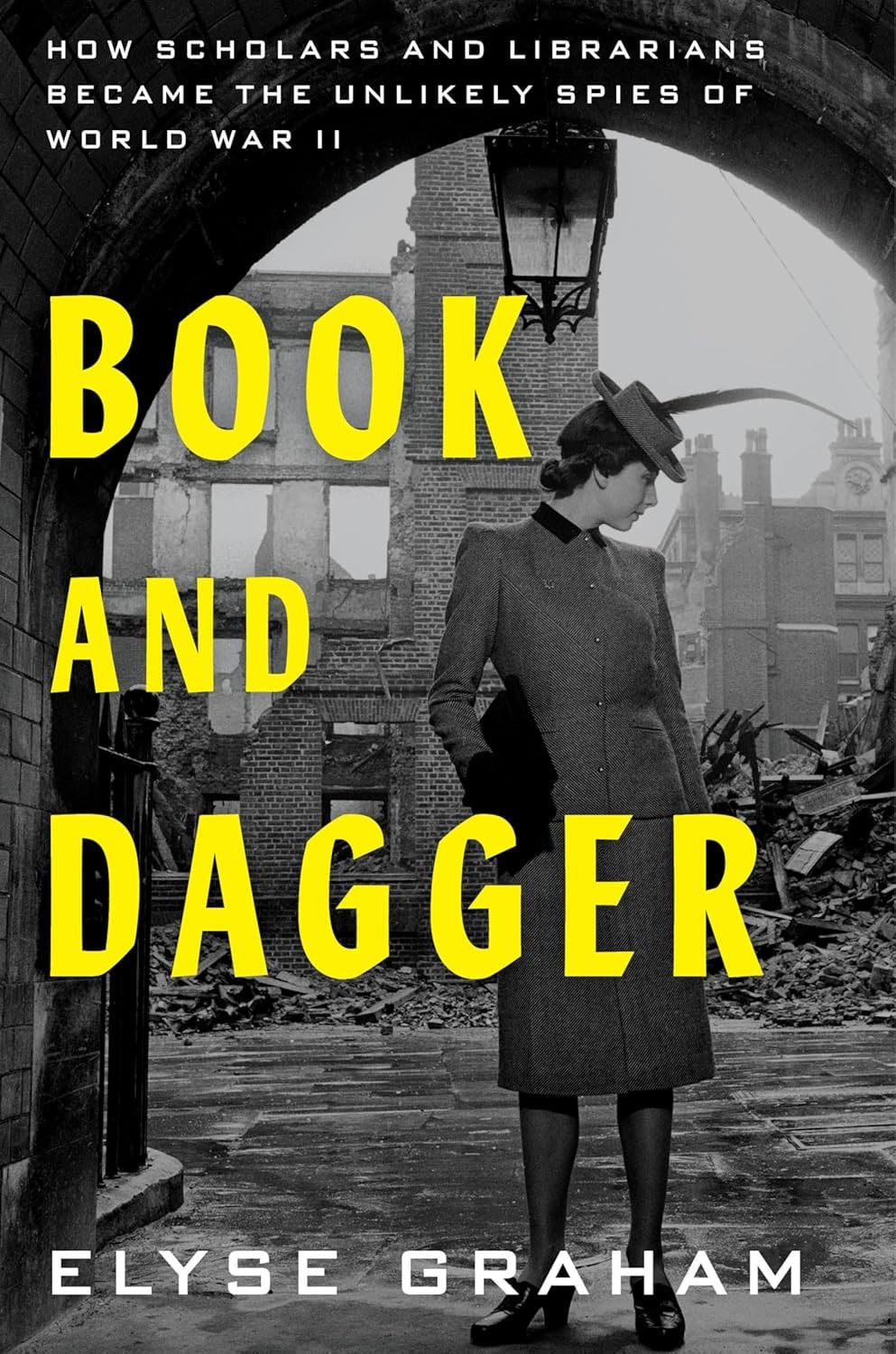 book cover for "book and dagger" by Elyse Graham, featuring a black and white photo of a woman in a long coat standing in front of the rubble of a demolished building.
