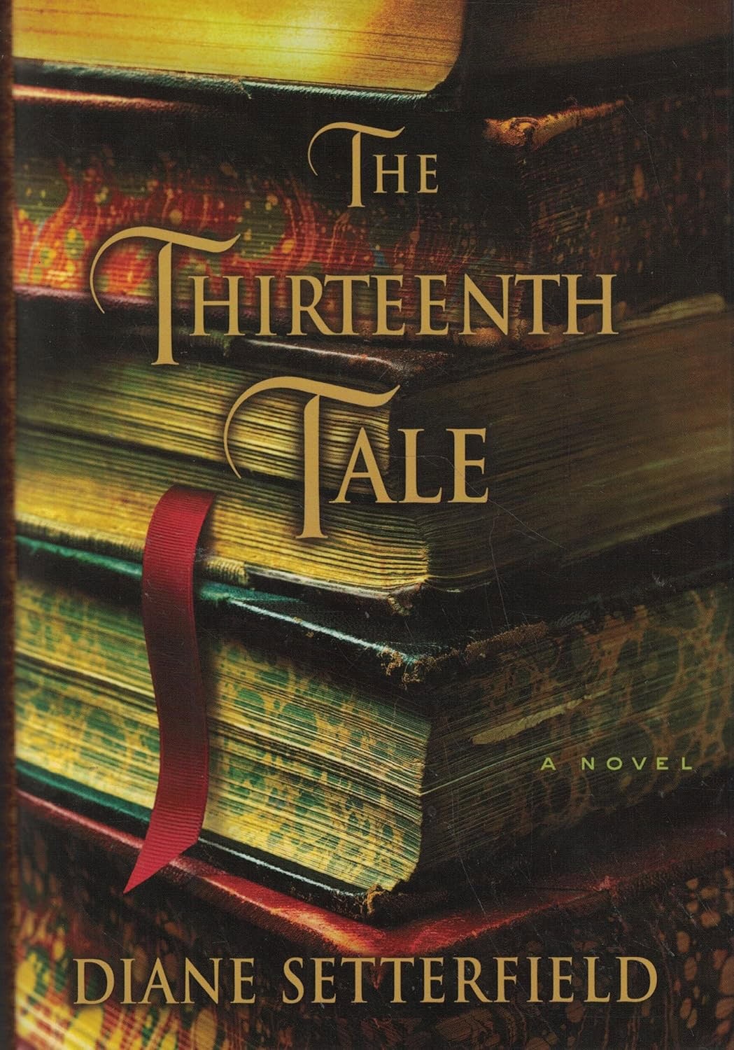 cover of the novel "the thirteenth tale" by diane setterfield, showing a stack of old books with a red ribbon between the pages.